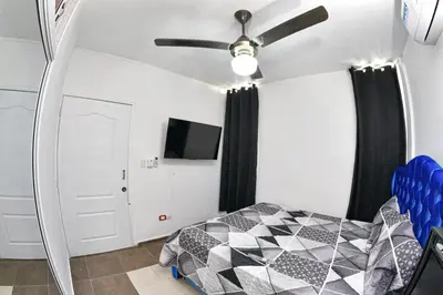 a bedroom with a bed and a ceiling fan at las carreras centro D la ciudad in Santiago de los Caballeros