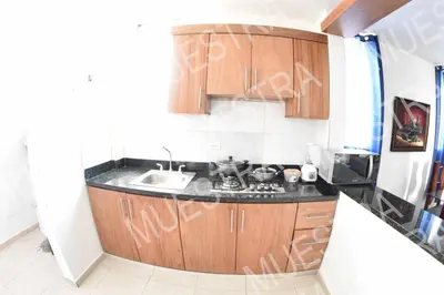 a small kitchen with wooden cabinets and a sink at las carreras centro D la ciudad in Santiago de los Caballeros