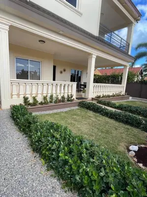 a house with a white fence and some bushes at Casa Canephora in Las Galeras