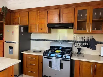 a kitchen with a stove and wooden cabinets at Casa Canephora in Las Galeras