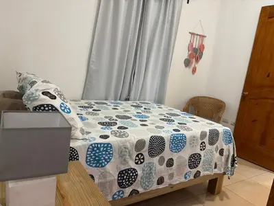 a bedroom with a bed with a comforter on it at Casa Canephora in Las Galeras