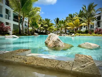 a swimming pool with a rock in the water at Apartment in Estrella, Dominicus-Bayahibe in La Laguna