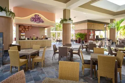 a dining room with tables and chairs in a restaurant at Riu Palace Bavaro - All Inclusive in Punta Cana