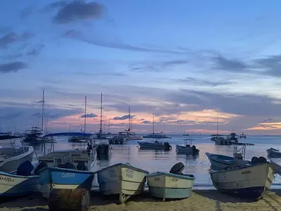 a group of boats sitting on the beach at sunset at Bridget Place in Bayahibe
