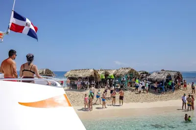 a group of people on a beach with umbrellas at LA CASA DE MAMA LUZ in San Felipe de Puerto Plata
