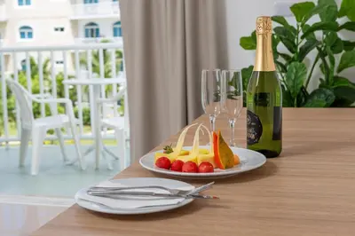 a table with a plate of fruit and a bottle of champagne at Hotel HM Alma de Bayahibe - Adults Only - All Inclusive in Bayahibe