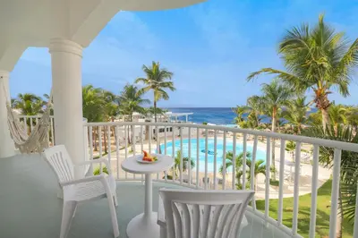 a balcony with a table and chairs and the ocean at Hotel HM Alma de Bayahibe - Adults Only - All Inclusive in Bayahibe