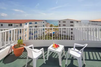 a balcony with chairs and a table and a view of the ocean at Hotel HM Alma de Bayahibe - Adults Only - All Inclusive in Bayahibe