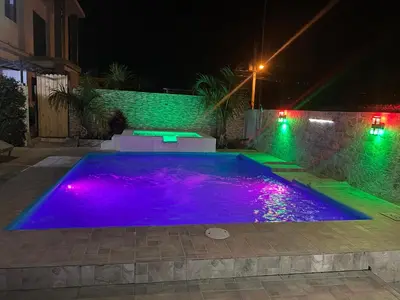a swimming pool at night with purple lights at VillaLunaCaridad in Jarabacoa