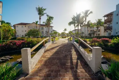 a bridge over a canal with palm trees and buildings at Apartment in Dominicus in Bayahibe