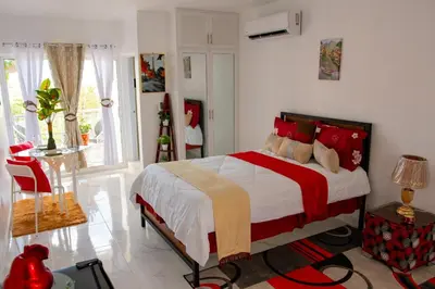 a bedroom with a bed with red and yellow pillows at Royal Terrace V (Duque) in San Felipe de Puerto Plata