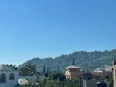 a view of a city with mountains in the background at Royal Terrace V (Duque) in San Felipe de Puerto Plata