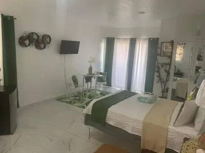 a bedroom with a bed and a table in it at Royal Terrace V (Duque) in San Felipe de Puerto Plata