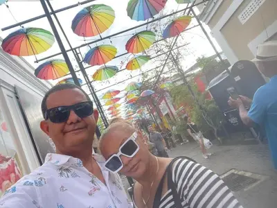a man and a woman posing for a picture under umbrellas at Royal Terrace III (Prince) in San Felipe de Puerto Plata