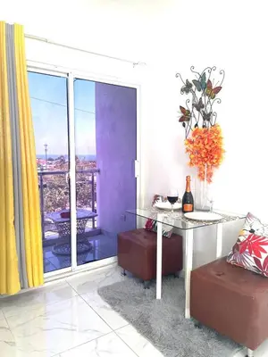 a living room with a table and a balcony at Royal Terrace III (Prince) in San Felipe de Puerto Plata