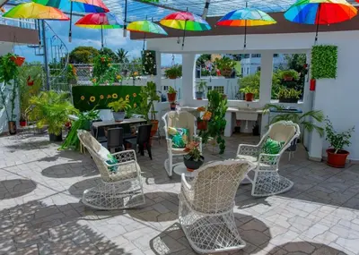 a patio with chairs and colorful umbrellas at Royal Terrace Apto. II (Princess) in San Felipe de Puerto Plata
