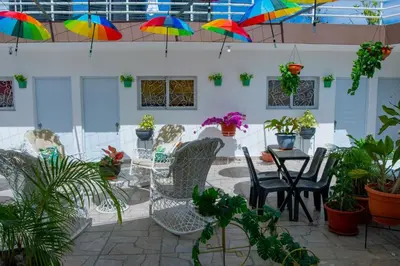 a patio with chairs and a table with colorful umbrellas at Royal Terrace Apto. II (Princess) in San Felipe de Puerto Plata