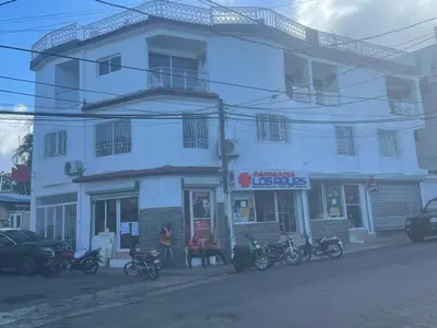 a white building with motorcycles parked in front of it at Royal Terrace Apto. II (Princess) in San Felipe de Puerto Plata
