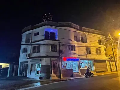 a building on a street at night with a person on a bike at Royal Terrace Apto. II (Princess) in San Felipe de Puerto Plata