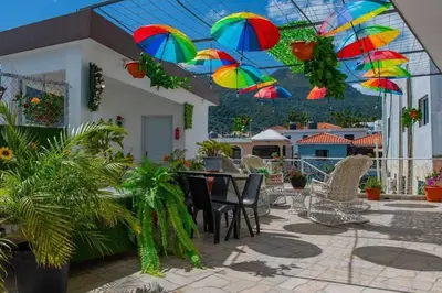 a patio with a table and chairs with colorful umbrellas at Royal Terrace I (Queen ) in San Felipe de Puerto Plata