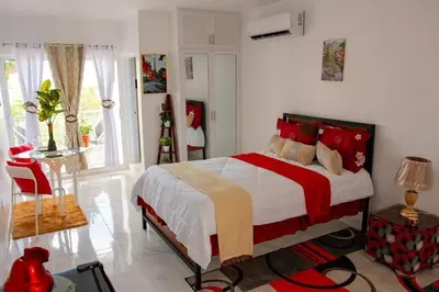 a bedroom with a large bed with red and yellow pillows at Royal Terrace I (Queen ) in San Felipe de Puerto Plata